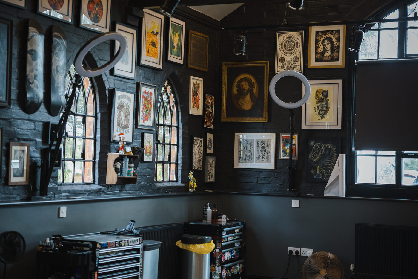 Tattoo station at The Church with gothic arched windows, framed flash and a ring light.